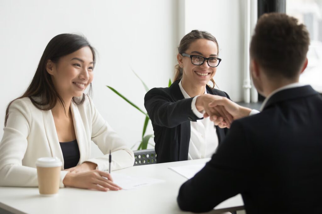 businessman-shaking-hand-female-coworker-company-meeting_1163-4678